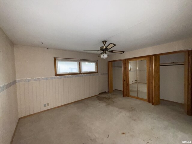 1117 E Ash St, Herrin, IL 62948 - unfurnished bedroom featuring light carpet, two closets, wainscoting, and ceiling fan