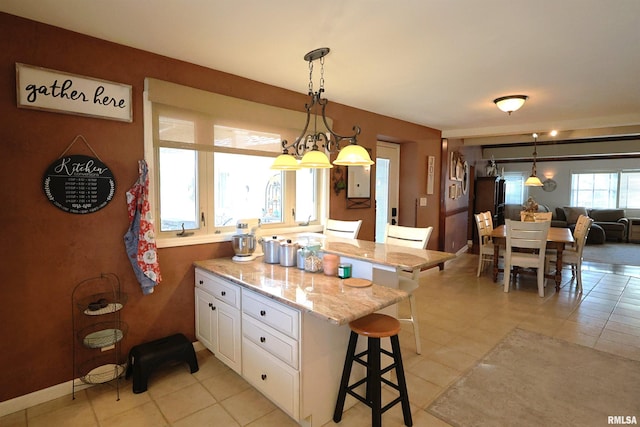 205 E Jennings, Salem, IL 62881 - kitchen with a breakfast bar area, white cabinetry, light tile patterned flooring, and a peninsula