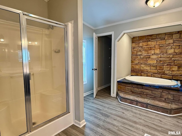 bathroom featuring hardwood / wood-style flooring, ornamental molding, and independent shower and bath