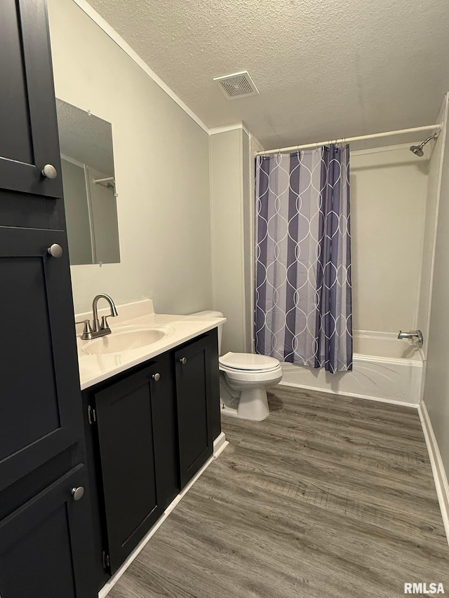 full bathroom with shower / tub combo with curtain, toilet, wood-type flooring, a textured ceiling, and vanity