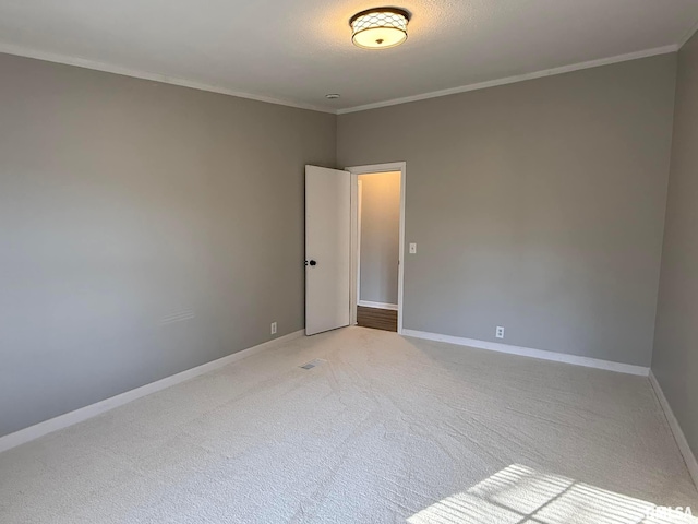 carpeted empty room featuring crown molding