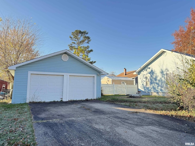 detached garage featuring fence