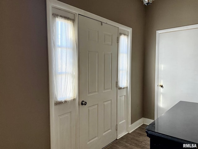 entrance foyer with dark wood-style flooring and baseboards