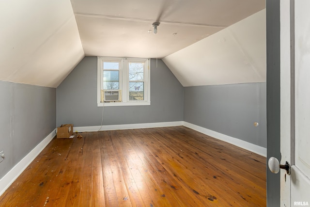 additional living space featuring vaulted ceiling, hardwood / wood-style floors, and cooling unit