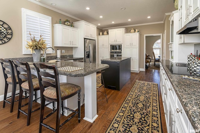 kitchen with a breakfast bar, white cabinets, dark stone counters, a center island, and stainless steel fridge with ice dispenser