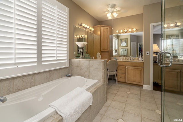 bathroom with vanity, tiled tub, tile patterned flooring, and a wealth of natural light