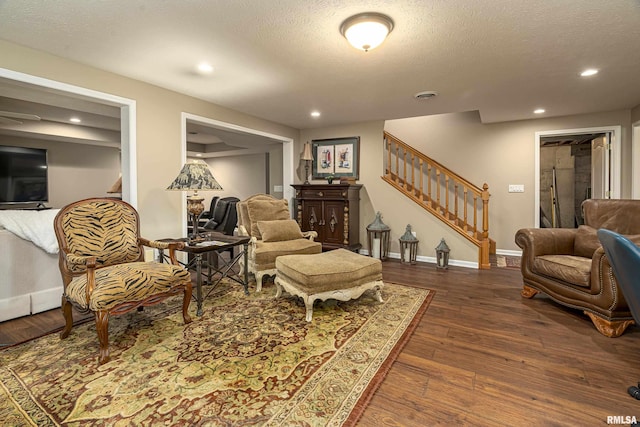 living room featuring a textured ceiling and dark hardwood / wood-style flooring