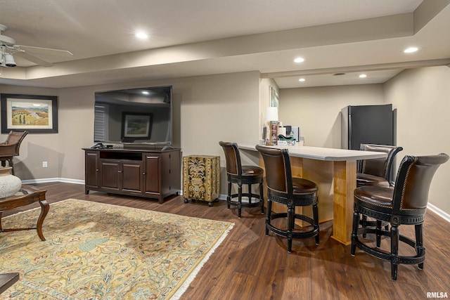 bar with dark wood-type flooring and ceiling fan