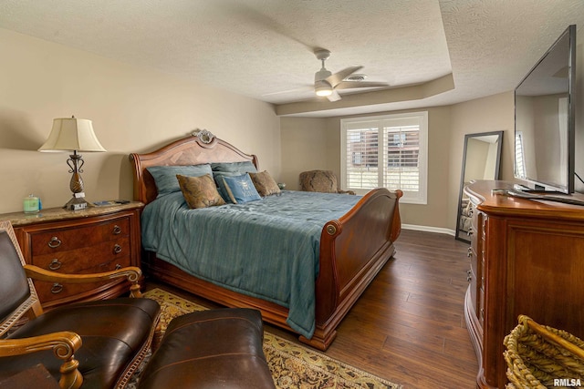 bedroom with dark hardwood / wood-style flooring, ceiling fan, and a textured ceiling