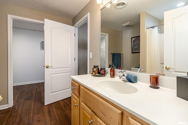 bathroom featuring a shower with shower curtain, vanity, hardwood / wood-style floors, and a textured ceiling