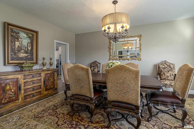 dining space with a textured ceiling and an inviting chandelier