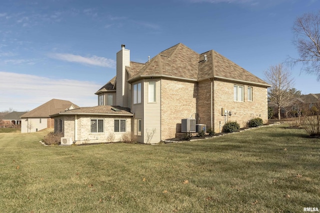 back of house with central AC and a lawn