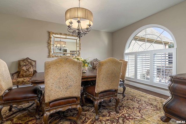 dining area with wood-type flooring and a chandelier