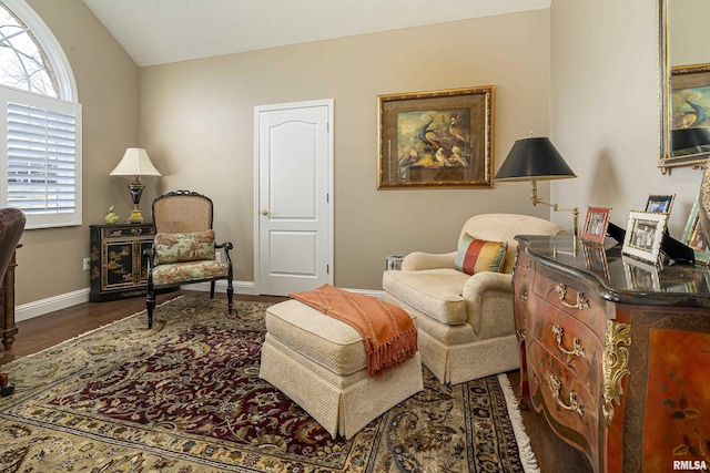 sitting room with dark wood-type flooring and vaulted ceiling