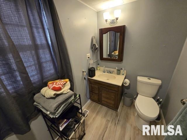 bathroom with wood-type flooring, toilet, and vanity