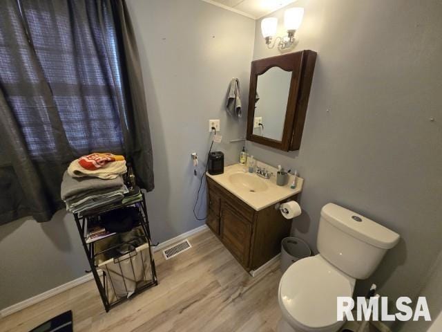 bathroom with wood-type flooring, vanity, and toilet