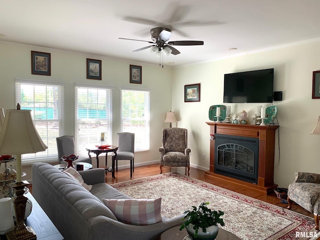 living room featuring hardwood / wood-style flooring, crown molding, and ceiling fan