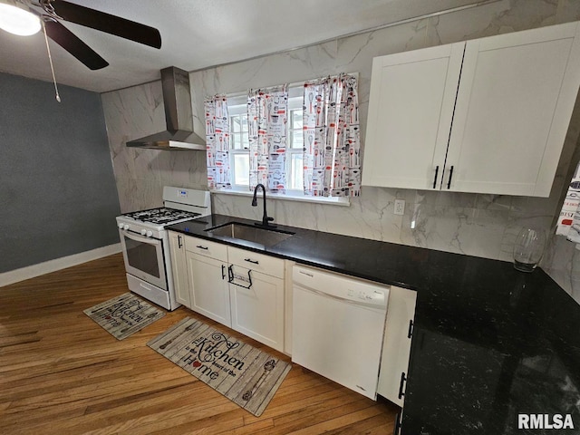 kitchen featuring white cabinetry, sink, wall chimney range hood, white appliances, and light hardwood / wood-style flooring