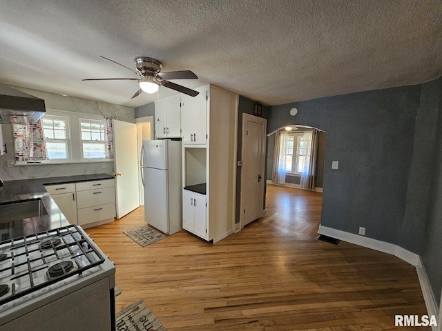 kitchen featuring white appliances, light hardwood / wood-style flooring, and white cabinets