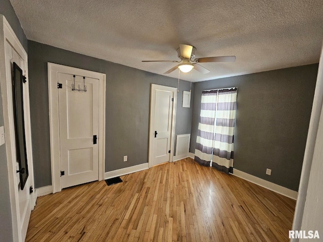 unfurnished bedroom with ceiling fan, a textured ceiling, and light hardwood / wood-style floors