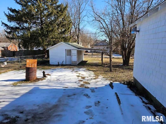 snowy yard featuring a shed