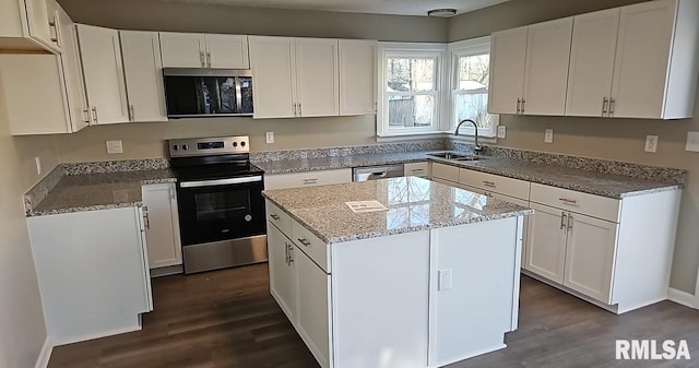 kitchen featuring white cabinetry, appliances with stainless steel finishes, sink, and a center island