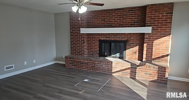 unfurnished living room with a fireplace, dark wood-type flooring, and ceiling fan