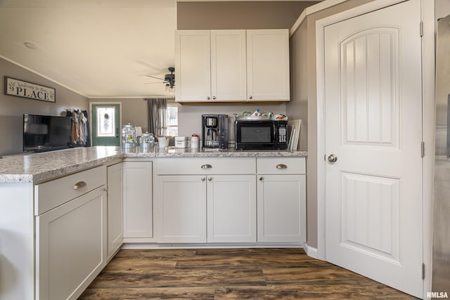 kitchen featuring vaulted ceiling, dark wood-type flooring, white cabinets, and kitchen peninsula