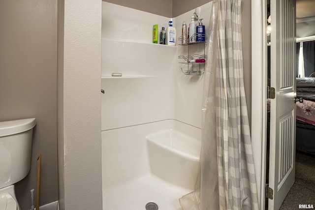 bathroom featuring curtained shower and toilet