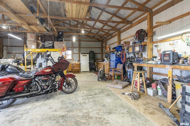 garage featuring white refrigerator and a workshop area