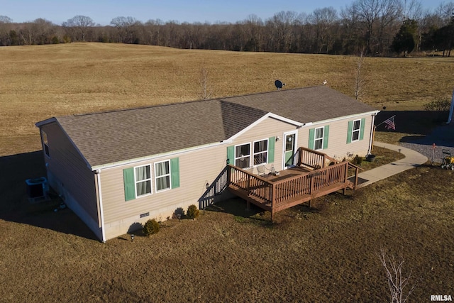 rear view of house with central AC, a rural view, a deck, and a lawn