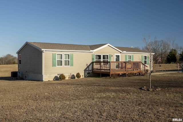 manufactured / mobile home featuring a wooden deck, a front lawn, and central air condition unit