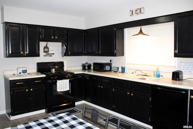 kitchen featuring pendant lighting, sink, and black appliances