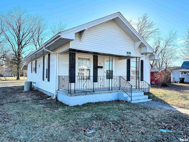 bungalow-style home featuring a porch, a front lawn, and central AC unit