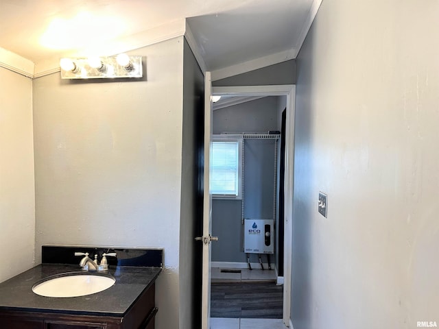 bathroom featuring vaulted ceiling, vanity, and crown molding