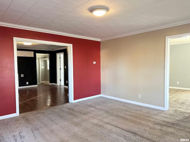 carpeted empty room with ornamental molding and baseboards