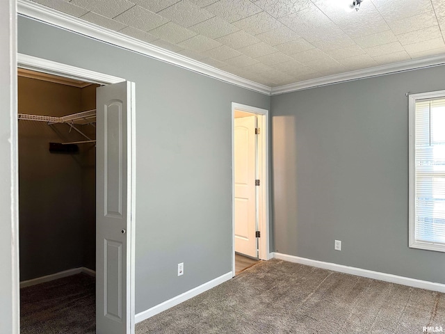 unfurnished bedroom with a spacious closet, multiple windows, carpet, and baseboards