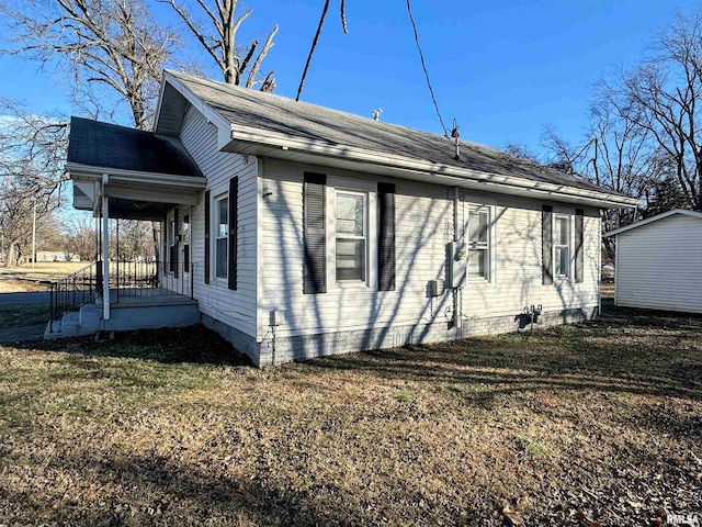 view of side of property with a porch and a lawn