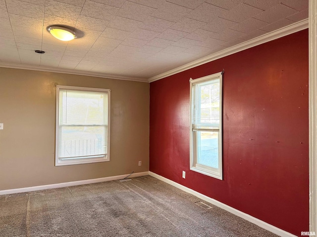 carpeted empty room featuring visible vents, baseboards, and crown molding