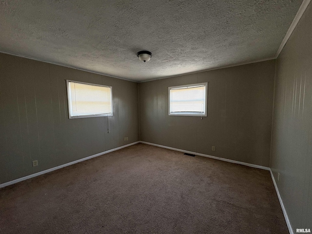 carpeted spare room featuring a textured ceiling