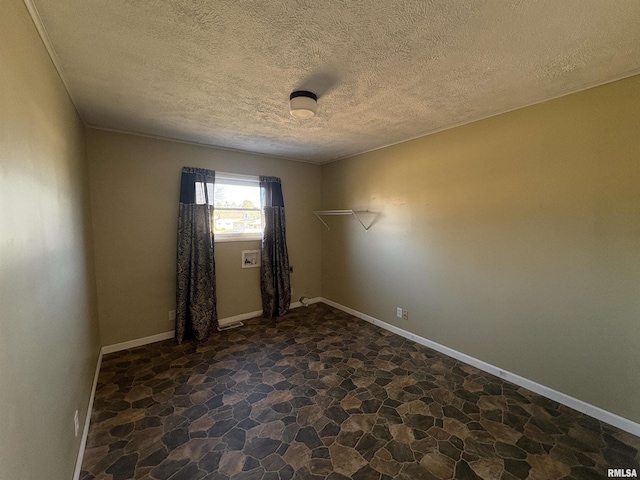 unfurnished room featuring a textured ceiling