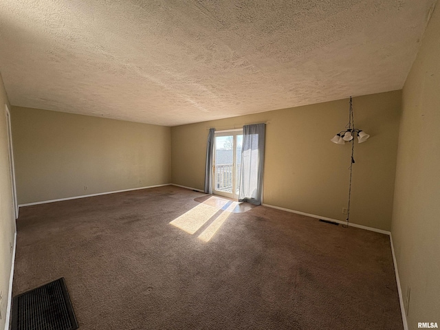 carpeted spare room featuring a textured ceiling