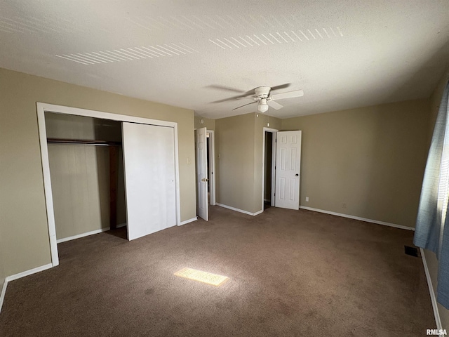 unfurnished bedroom featuring ceiling fan, a closet, a textured ceiling, and dark colored carpet