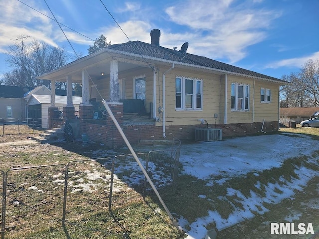 back of property with cooling unit and covered porch