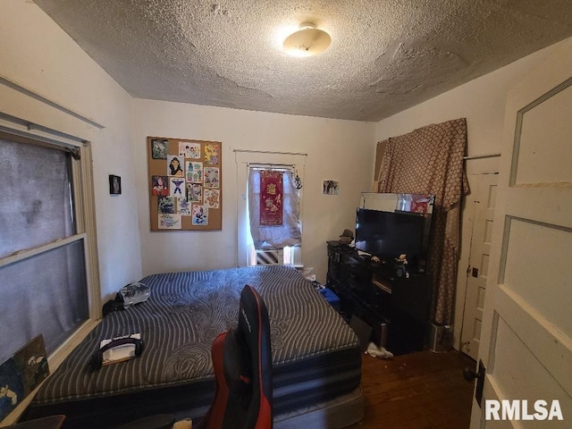 bedroom featuring wood-type flooring and a textured ceiling