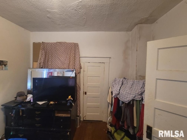 bedroom with a textured ceiling and dark hardwood / wood-style flooring