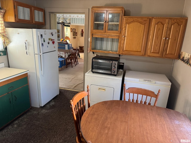 kitchen featuring refrigerator, dark carpet, washer / dryer, and white fridge