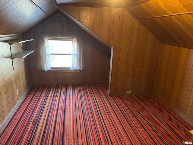 bonus room with lofted ceiling, dark carpet, and wooden walls