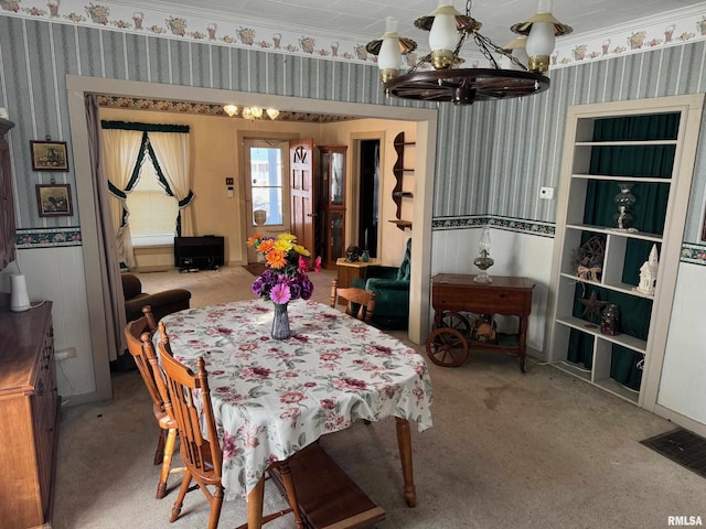 carpeted dining space featuring crown molding