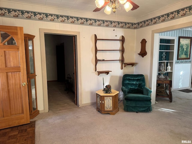 sitting room with ornamental molding, ceiling fan, and carpet flooring